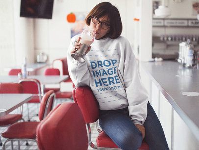 Crewneck Mockup of a Cool Girl with Short Hair and Glasses Drinking a Milkshake at a Diner a12665