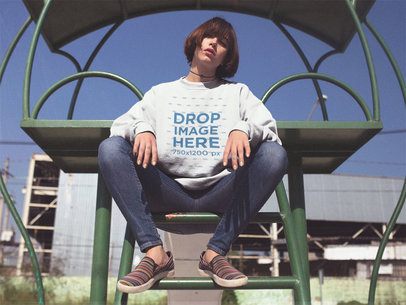 Crewneck Mockup of a Young Asian Woman with Short Hair Sitting on a Green Ladder a12654