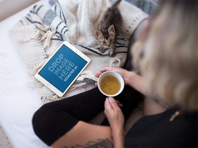 Mockup of a Woman in Bed Watching Her iPad Mini and Holding a Coffee Cup a12809