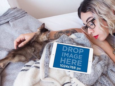 iPad Mini Mockup in Landscape View on a Bed with a Trendy Girl and her Cat a12792