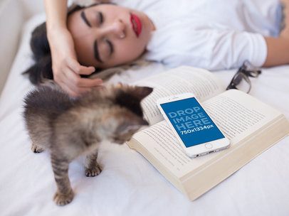 White iPhone 6s Mockup of a Woman Sleeping on her Bed with a Kitten and a Book