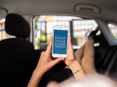 White iPhone Mockup Held in Portrait Position by a Woman Lying in the Backseat of a Car