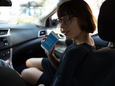 Mockup of a Woman Showing an iPhone in a Car