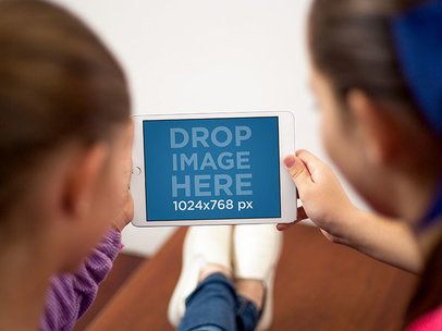 Two Little Girls Using an iPad Mini in Landscape View Mockup at their Home a12992