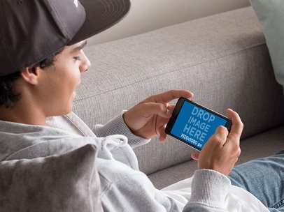 iPhone Mockup in Landscape Position of a Young Man Chilling 