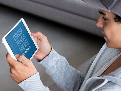 Mockup of a Young Man Using an iPad Mini in Landscape Position 