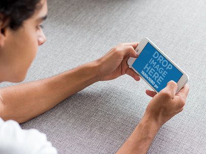 Mockup of an iPhone Featuring a Young Man against a Gray Background
