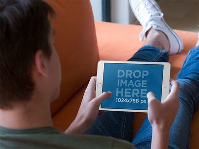 iPad Mockup in Landscape Position Featuring a Man Resting on a Sofa