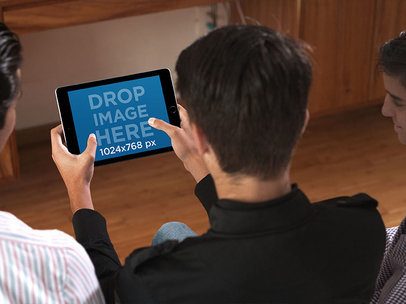 Black iPad Mini in Landscape Position Mockup Featuring Three Teenagers Playing in their Living Room