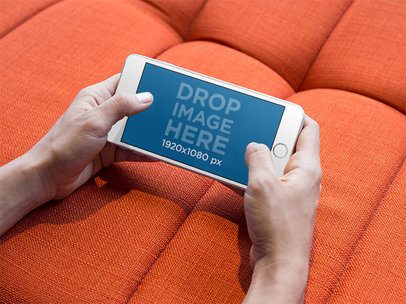 iPhone Mockup in Landscape Position against an Orange Sofa