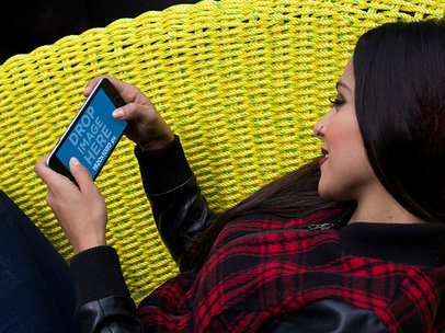 Mockup of a Woman Staring at an iPhone in Landscape Position