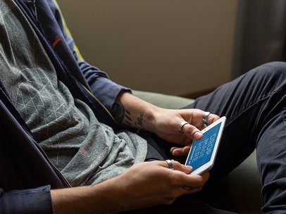 Mockup of an iPhone 7 Plus Featuring a Guy Sitting in his Room Playing