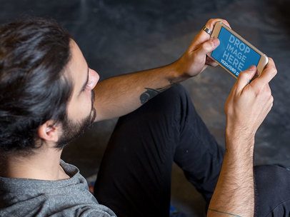 iPhone 6 Plus Mockup in Landscape View of a Young Man Playing at his Apartment