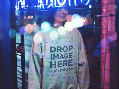 Crewneck Mockup of a Pretty Young Woman in a Coffee Shop at Night