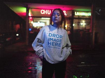 Crewneck Sweatshirt Mockup of a Young Asian Woman in Front of Neon Street Lights