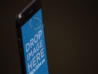 Angled Close Up Shot Mockup of a Black iPhone Standing in Portrait Position