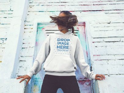 Pullover Hoodie Mockup of a Young Woman Flipping her Hair in the Street