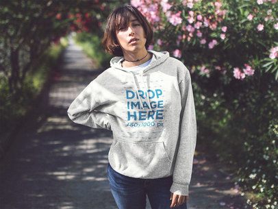 Pullover Hoodie Mockup of an Asian Woman Near a Flower Garden