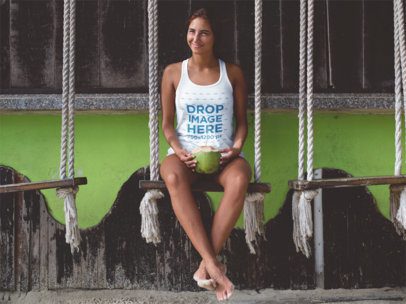 Lovely Beach Woman Wearing a Tank Top While Having a Coconut on a Swing