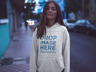 Pretty Woman on the Street at Dusk Wearing a Pullover Hoodie Mockup