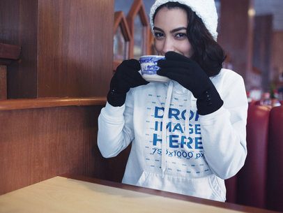 Pullover Hoodie Mockup of a Woman with Gloves Drinking Hot Cocoa Inside