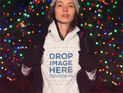 Lovely Woman Wearing a Hoodie Mockup with a Jacket in Front of Christmas Lights a13245