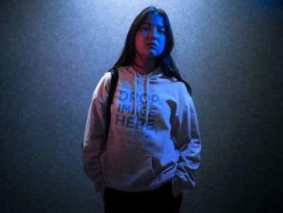 Hoodie Mockup of a Trendy Asian Girl with Long Hair Standing in a Blue Light a12717