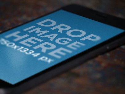 Black iPhone in Portrait Position Lying Over a Table Close Up Shot Mockup