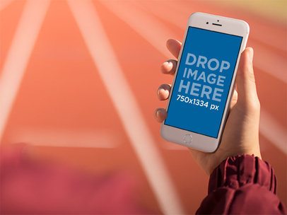 Runner Looking At His White iPhone 6 While On A Speed Track Mockup a14100