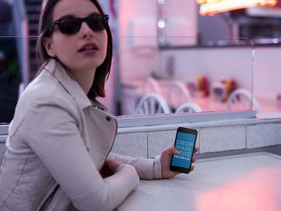 Mockup of a Woman Posing at Sunset with an iPhone 6