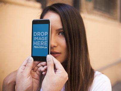 Mockup of a Woman Hiding Behind an iPhone in Portrait Position  a14034
