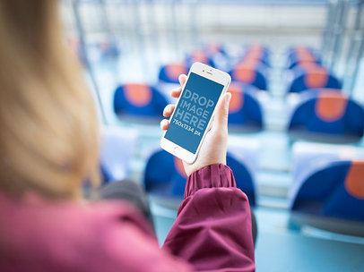 Mockup of a Woman at a Stadium Holding an iPhone 6