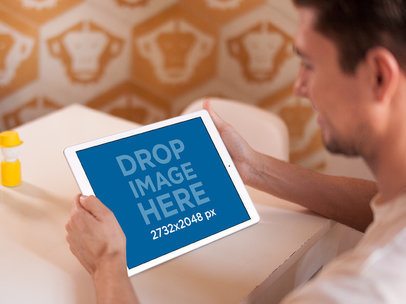 Over-the-Shoulder Mockup of a Man Holding an iPad in Landscape Mode