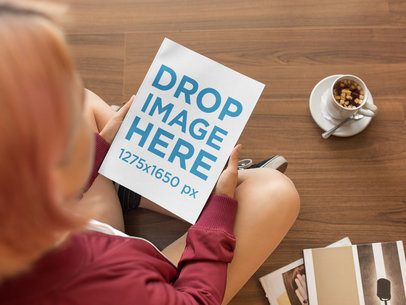Mockup of a Girl Holding a Book While Sitting Down on a Wooden Floor a14364