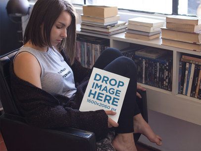 Young Pretty Lady With Short Hair Holding a Book While Near a Window Mockup a14266