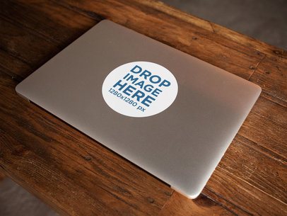 Sticker on a Closed MacBook Over a Wooden Surface Template