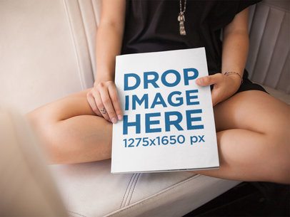 Girl Showing a Big Magazine While Sitting Inside a Small Car With White Leather Seats Mockup a14398