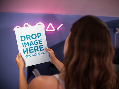 Over Shoulder Mockup of a Girl Holding a Magazine in a Room With Pink Neon Lights a14403