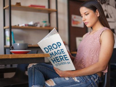 Gorgeous Young Woman Reading a Magazine While Having a Coffee in the Morning