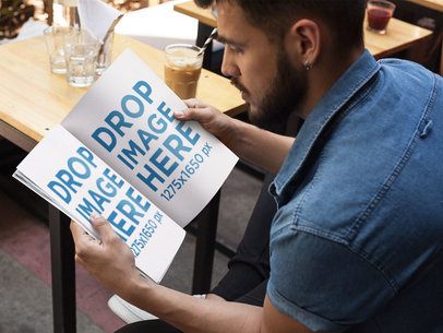 Mockup of a Young Man With Beard Reading a Magazine While at a Coffee Shop a14444