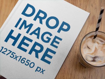 Magazine Lying on a Wooden Table with an Iced Coffee Beside It a14448