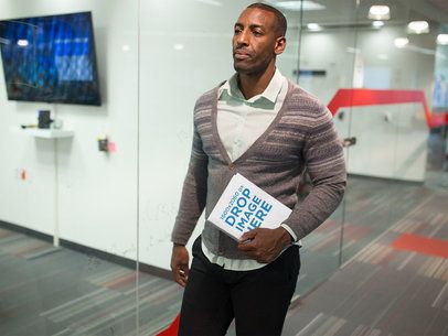 Man Holding a Book While Walking Through an Office Mockup a14509