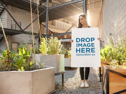 Pretty Lady Holding a Poster While in a Terrace Against the Sunset