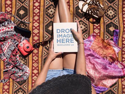 Tanned Girl Holding a Book on her Lap While Sitting Down at the Beach Mockup a14292