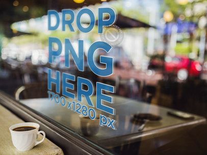 Mockup of a Window Decal With a Coffee Cup on a Table Alongside It a14520