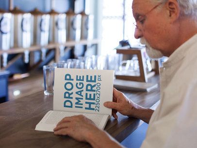 Elder Man Reading a Book While Waiting for his Coffee Sitting on a Table Mockup