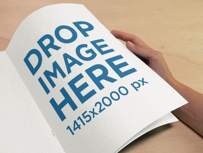 Mockup of a Woman Reading a Catalog on a Wooden Table