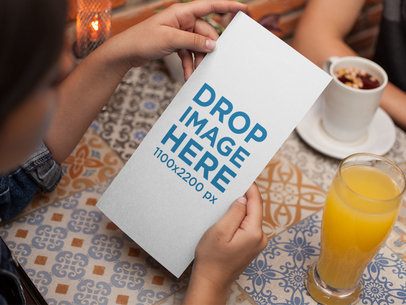 Young Woman Reading a Vertical Restaurant Menu Mockup