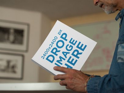 Mockup of a Man Reading a Square Book While in his House