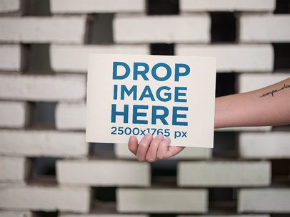 White Girl with a Tattoo Holding a Horizontal Catalog Mockup a14641